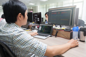 Asian Developer Using Laptop Computer Sitting Working